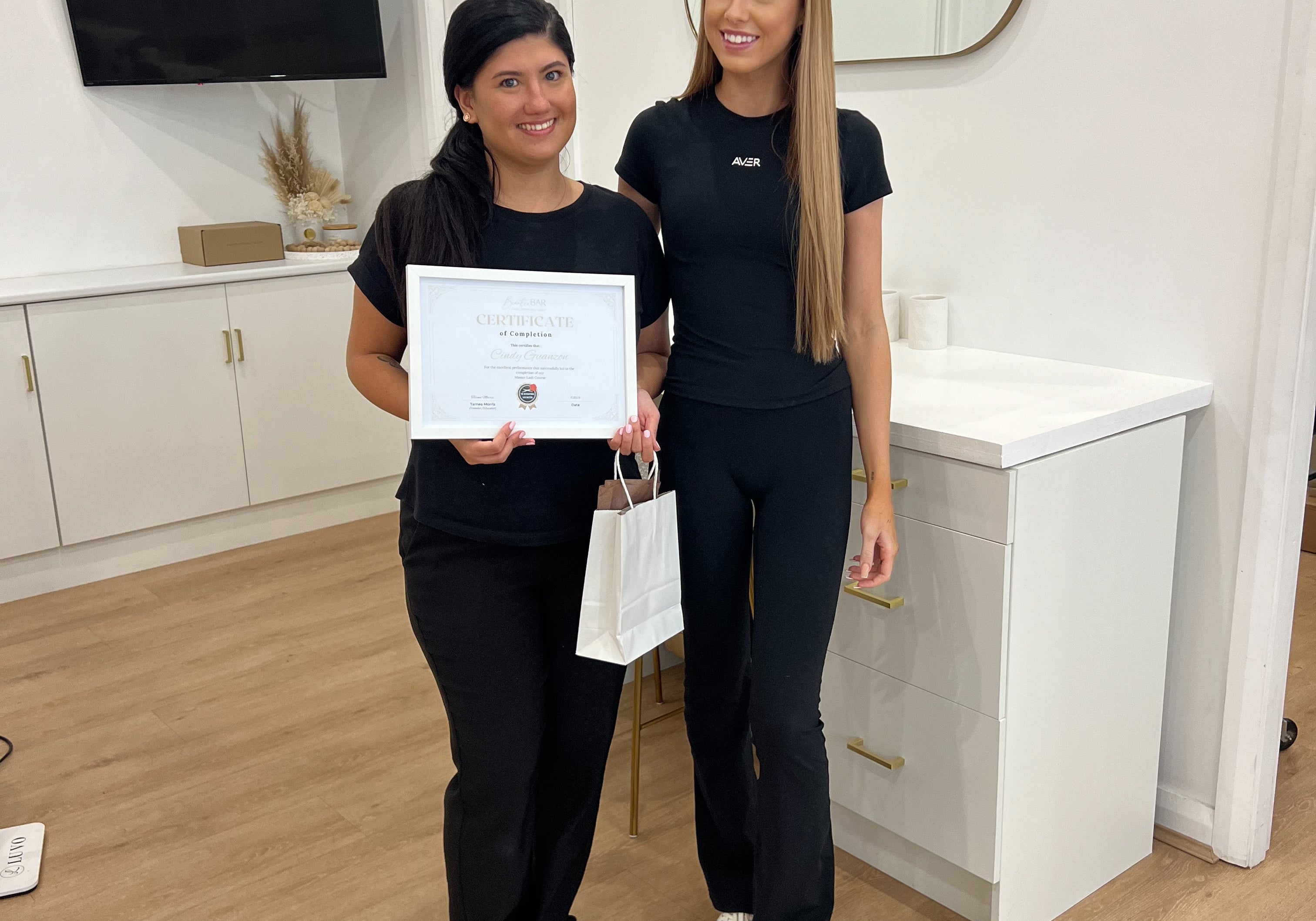 Student receiving a certificate of completion from a Lash and Brow Educator at By Tarnee Morris in Penrith, celebrating success in a professional lash and brow training course.